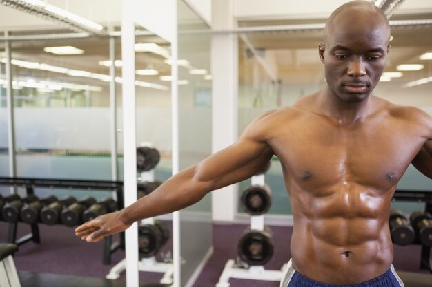 Homem musculoso sem camisa grave na academia