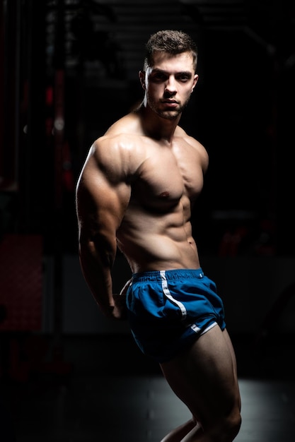 Homem na academia mostrando seu corpo bem treinado