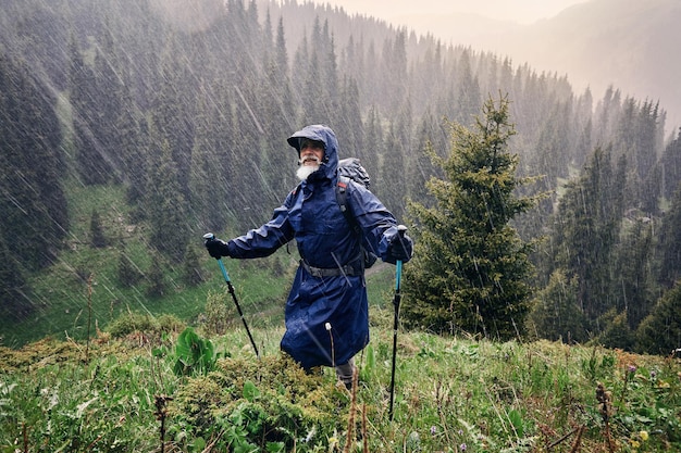 Homem na capa de chuva ao ar livre