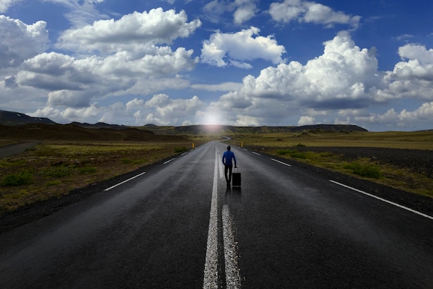 Homem na estrada com sua mala