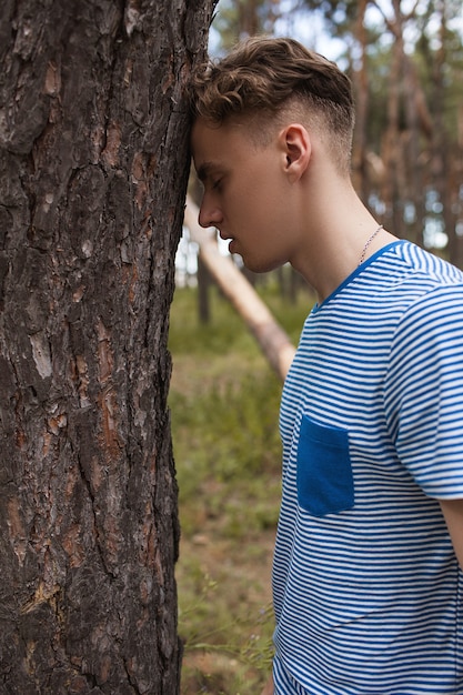 Foto homem na floresta. jovem sonhador entre as árvores