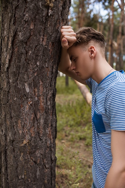 Foto homem na floresta. jovem sonhador entre as árvores