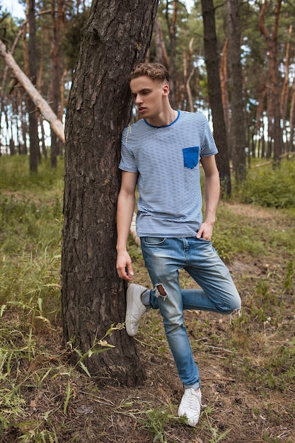 Foto homem na floresta. jovem sonhador entre as árvores