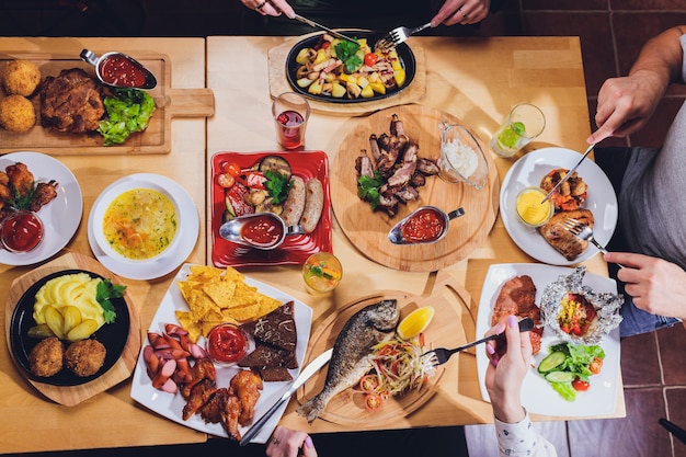 Homem na mesa grande com comida.