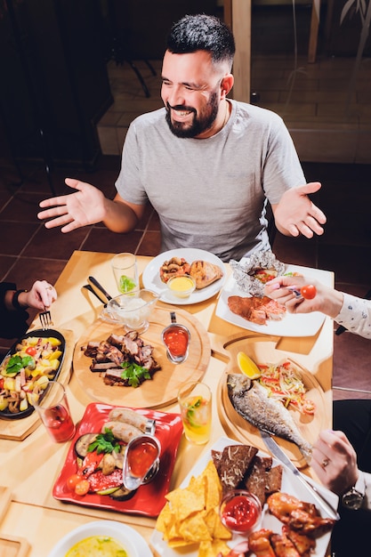 Homem na mesa grande com comida.