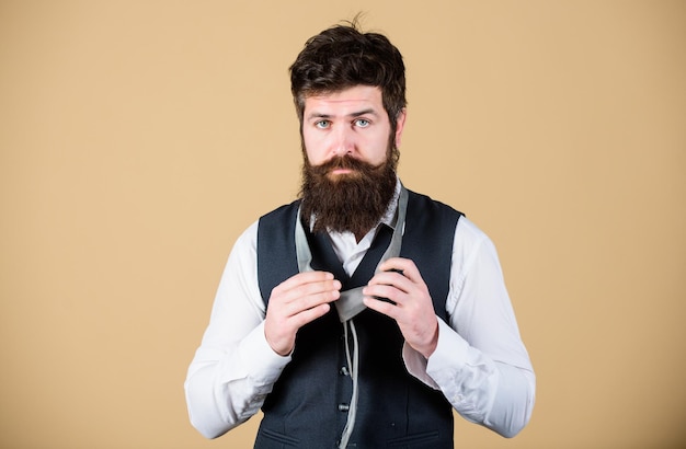 Homem na moda bastante formal Homem barbudo amarrando uma gravata Homem caucasiano brutal ajustando acessório de moda Homem com barba longa e bigode vestindo em estilo clássico