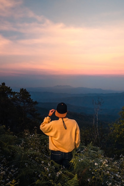 Foto homem na montanha com o crepúsculo à noite.