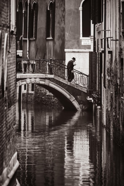 Homem na ponte de um dos canais de veneza