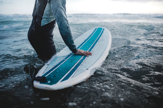 Homem na praia com sua prancha de surf