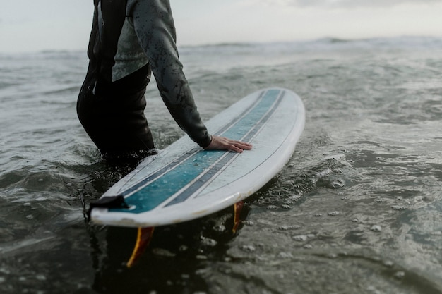 Homem na praia com sua prancha de surf