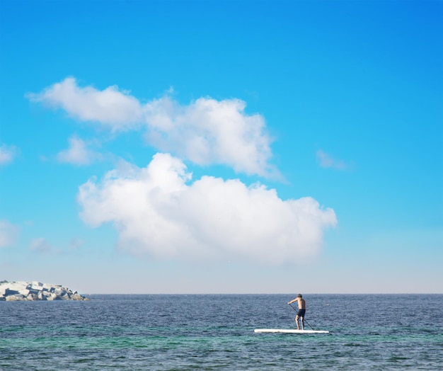 Homem na prancha de stand up paddle