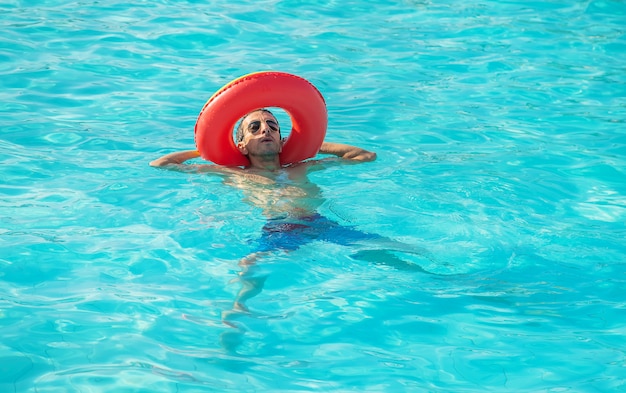 Homem nada em uma piscina com um círculo.