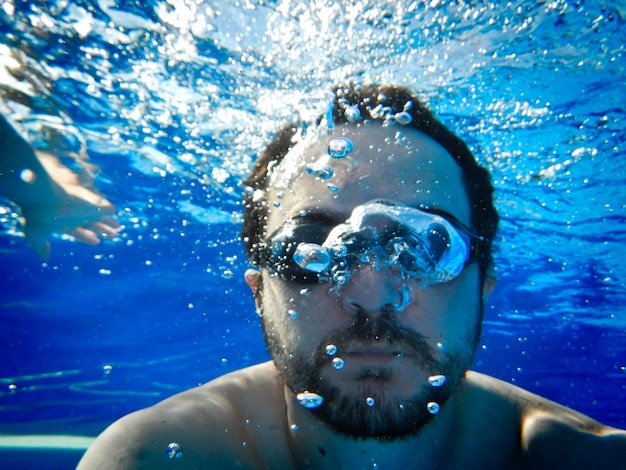 Homem nadando debaixo d'água na piscina