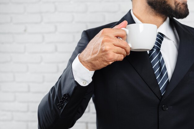 Homem negócio, em, um, terno negócio, e, um, xícara café