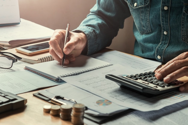 Foto homem negócio, usando, calculadora, para, calcular, com, escrita, de, dados, finanças, contabilidade