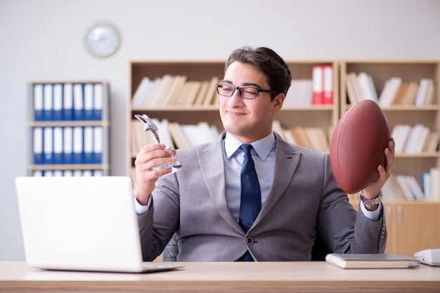 Homem negócios, com, futebol americano, em, escritório