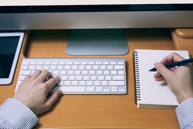 Homem negócios, digitando, teclado, e, nota escrevendo