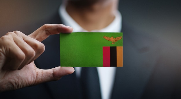 Homem negócios, segurando, cartão, de, bandeira zâmbia