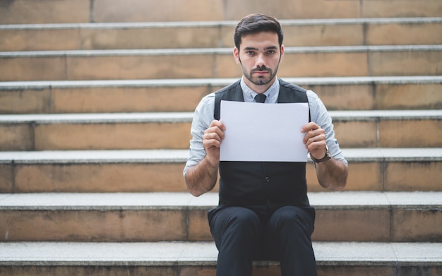 Homem negócios, segurando, vazio, branca, papel, sentando, ligado, a, escadas