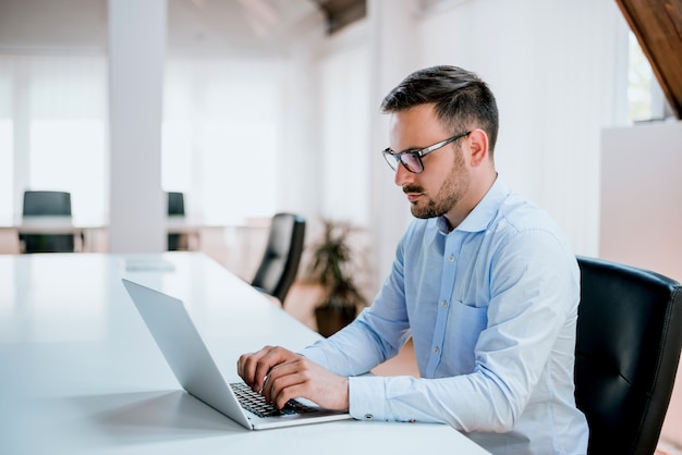 Homem negócios, sentando, em, escrivaninha escritório, trabalhar, computador laptop