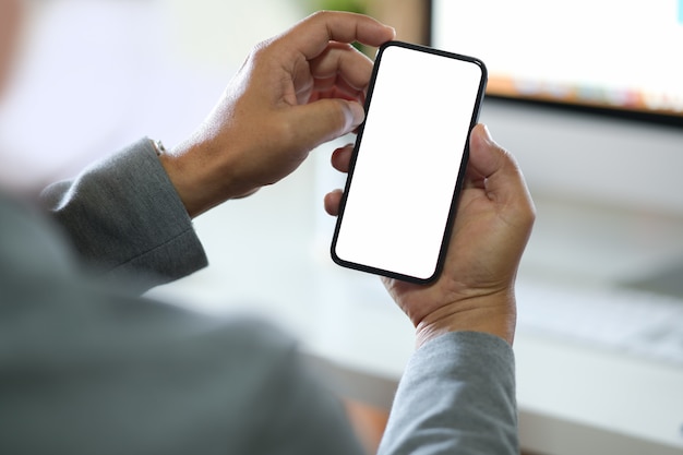 Homem negócios, usando, smartphone Telefone celular da tela vazia para a montagem da exposição gráfica.