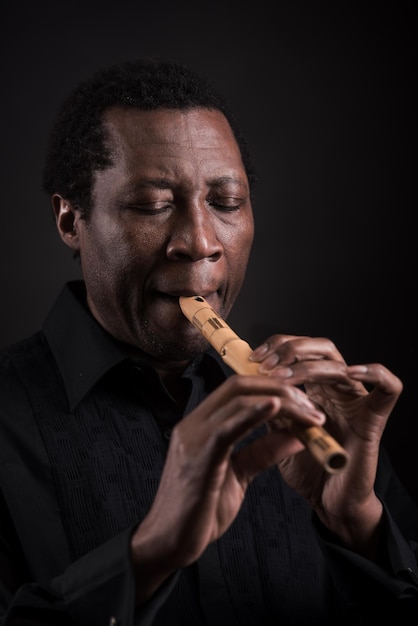 Homem negro africano com instrumento musical étnico