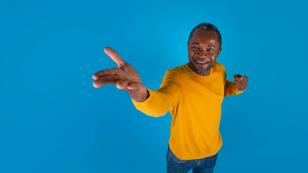 Homem negro alegre mostrando algo na mão