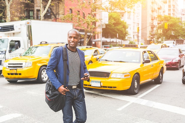 Homem negro atravessando uma rua em Nova York.