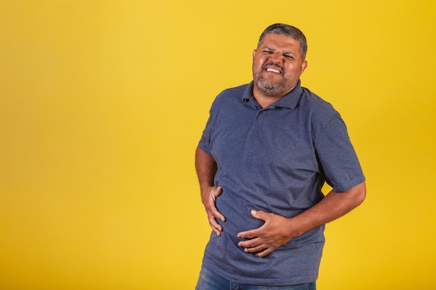 Homem negro brasileiro adulto com dor de estômago