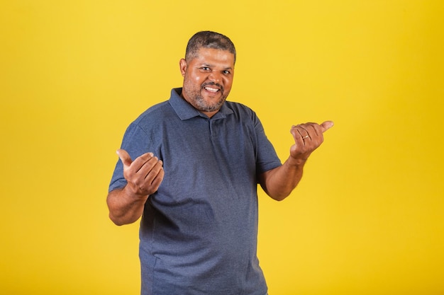 Homem negro brasileiro adulto sorrindo convidando com as mãos chamando venha