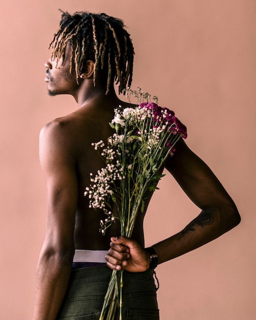 Homem negro carregando um buquê de flores nas costas