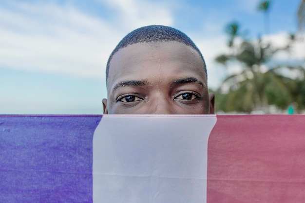 Homem negro cobrindo o rosto com bandeira