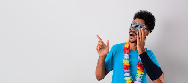 Homem negro com fantasia de carnaval apontando isolado no branco