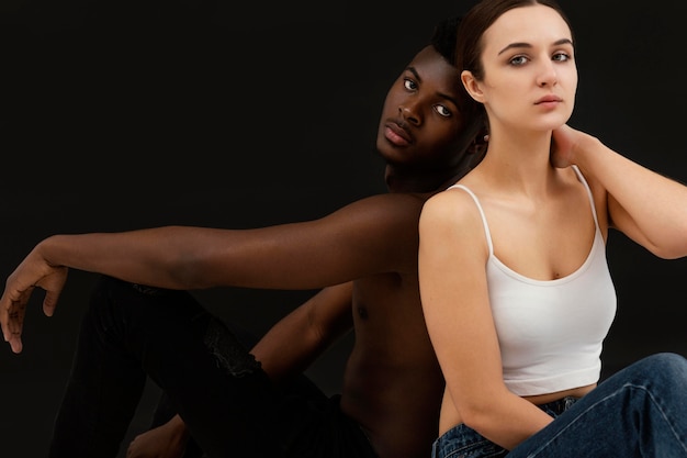 Homem negro de tiro médio e mulher branca posando
