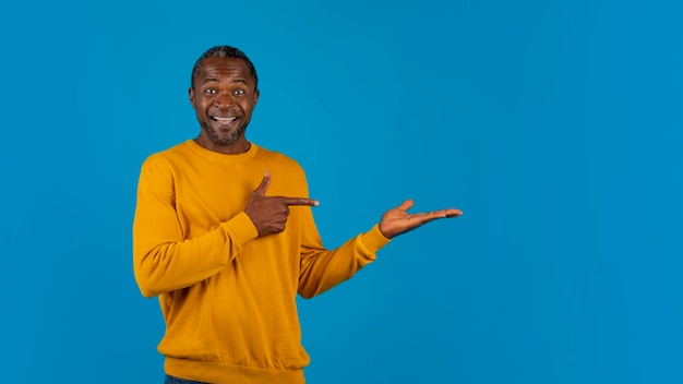 Homem negro feliz mostrando algo na mão