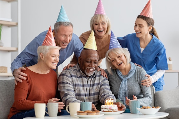 Homem negro idoso tendo festa de aniversário no lar de idosos