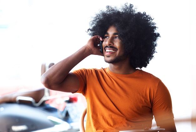 Homem negro jovem bonito falando no celular