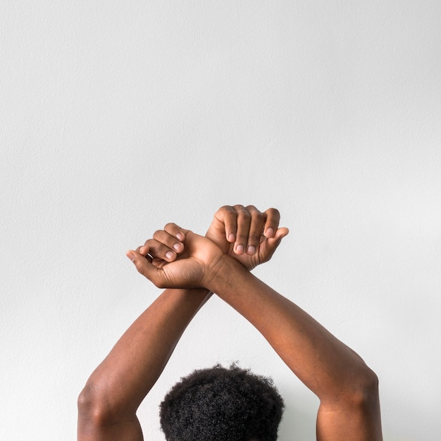 Homem negro levantando as mãos