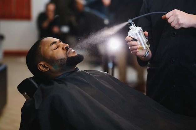 Homem negro na barbearia do salão africano