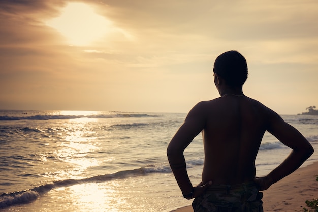 Homem negro na praia ao pôr do sol