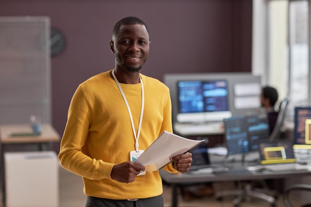 Homem negro sorridente como engenheiro de TI no escritório