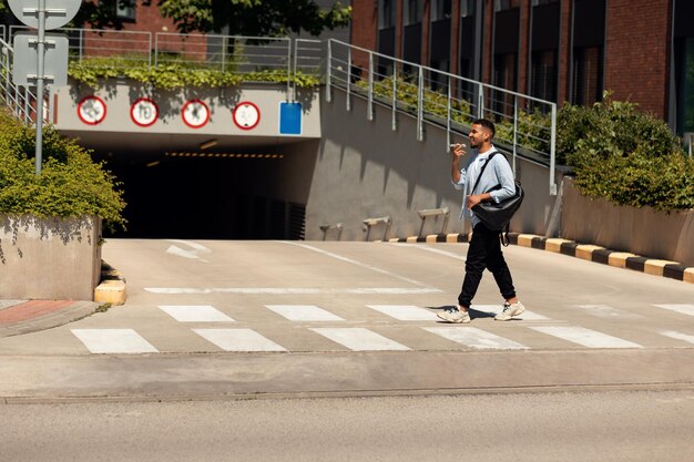 Homem negro sorridente falando ao telefone andando na cidade