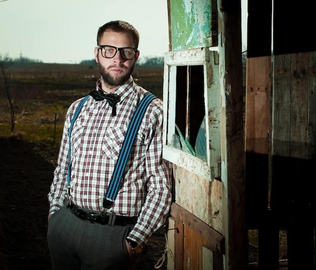 Homem nerd caipira de óculos com barba ao ar livre