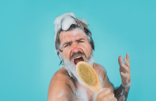 Homem no chuveiro homem canta no chuveiro homem com escova corporal shampoo lavando a cabeça homem barbudo lavando o cabelo