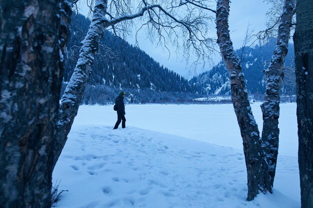 Homem no lago congelado da montanha