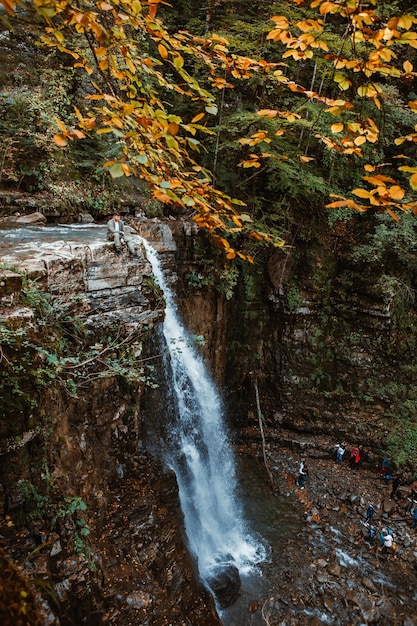 Homem no topo da cachoeira no espaço da cópia da floresta de outono
