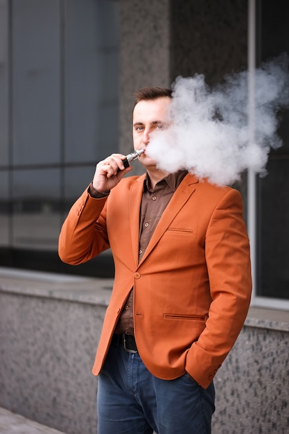 Foto homem novo que fuma o cigarro eletrônico