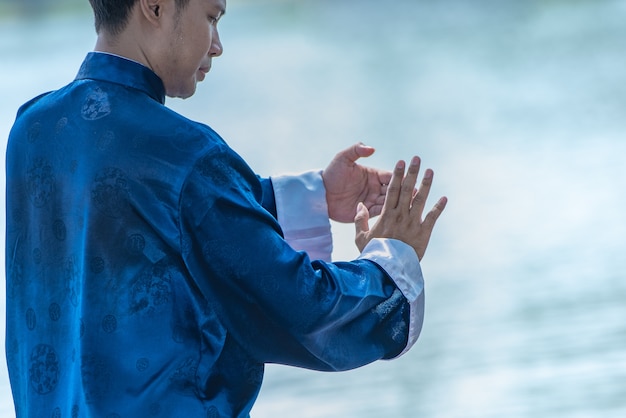 Homem novo que pratica o gongo tradicional de tai chi chuan, de tai ji e de qi, artes marciais chinesas.