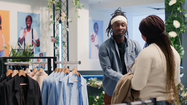 Homem numa boutique de moda a experimentar roupas
