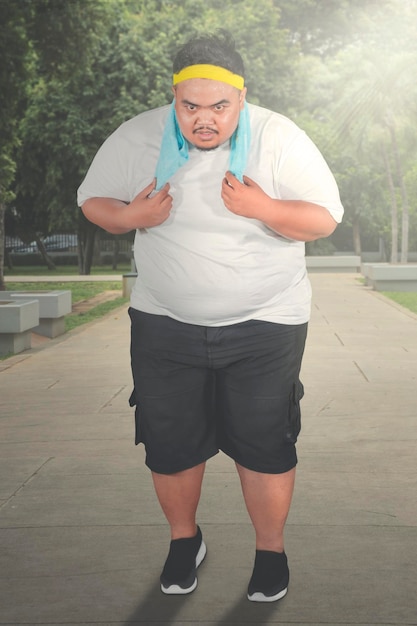 Homem obeso cansado correndo no parque